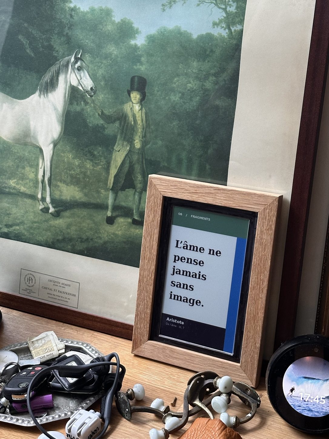 Cadre de chêne en couleur, posé devant une gravure, affichant « L’âme ne pense jamais sans image » d’Aristote, avec un bandeau vert et une marge bleue.
